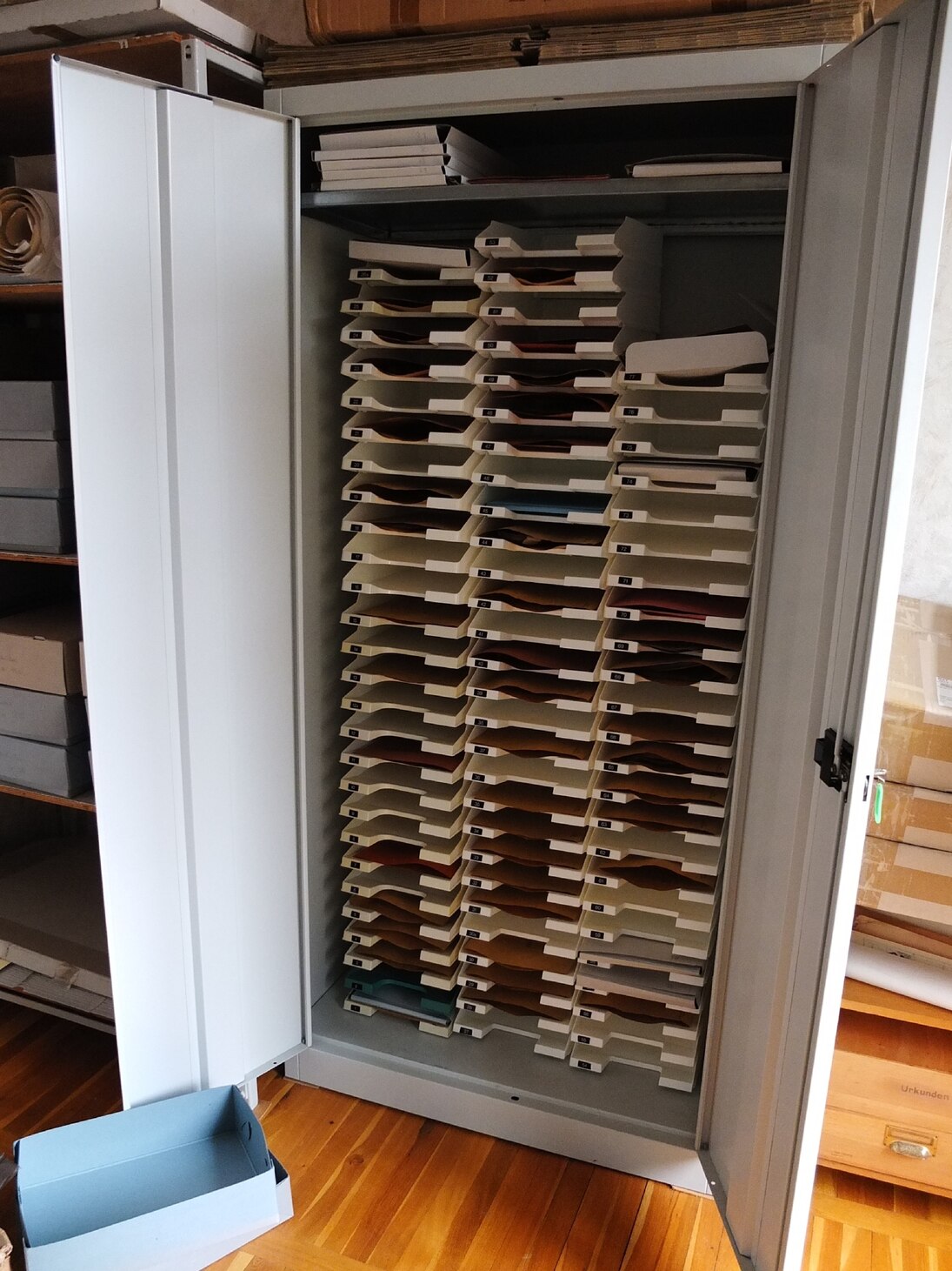 Geöffneter Metallschrank mit darin liegenden Urkunden.