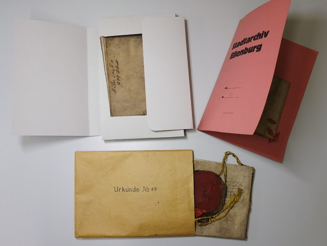 Drei Urkunden in alten Umschlägen.