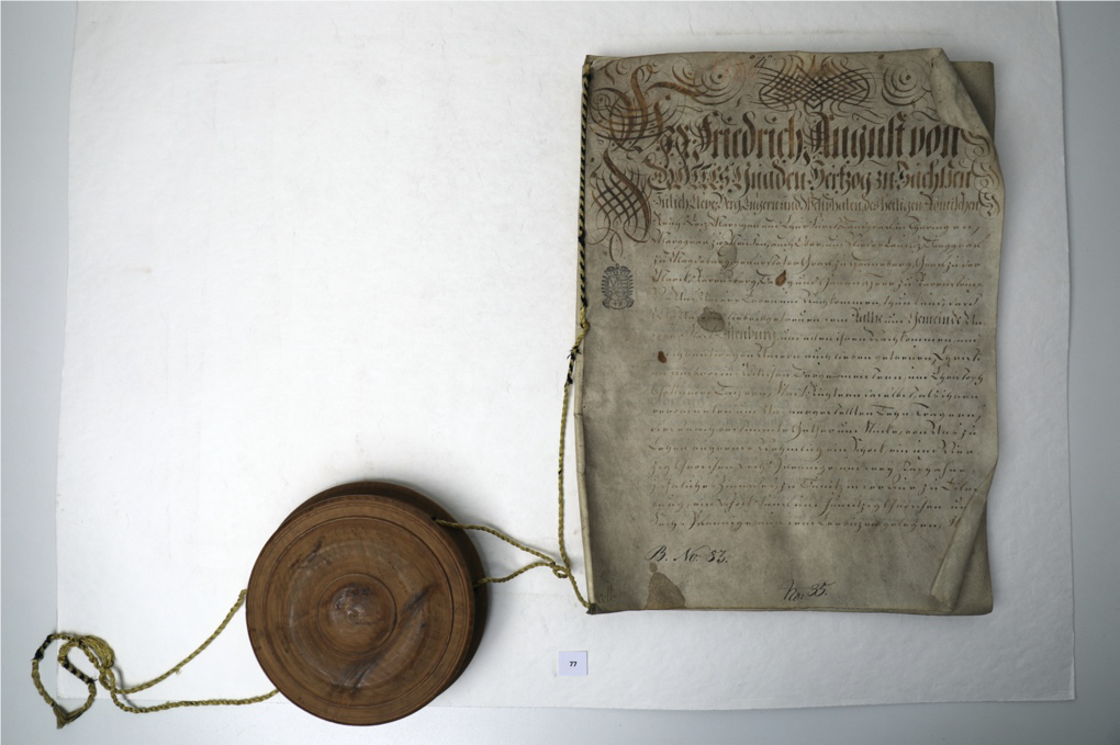 Stark verschmutzte Urkunde mit Siegel.