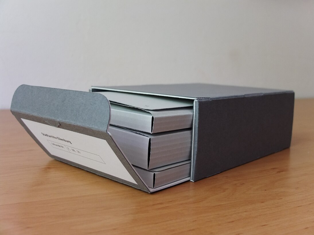 Geöffnete Schachtel mit Mappen.