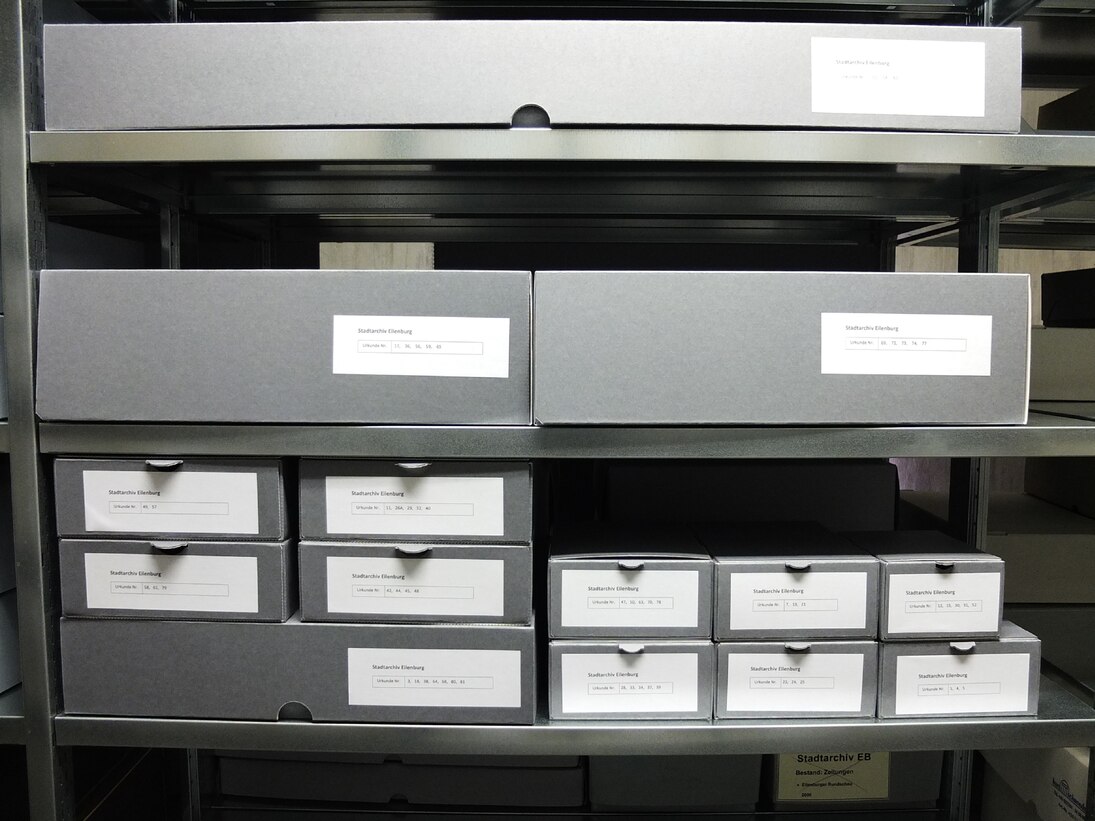 Regal mit Archivschachteln in verschiedenen Größen.