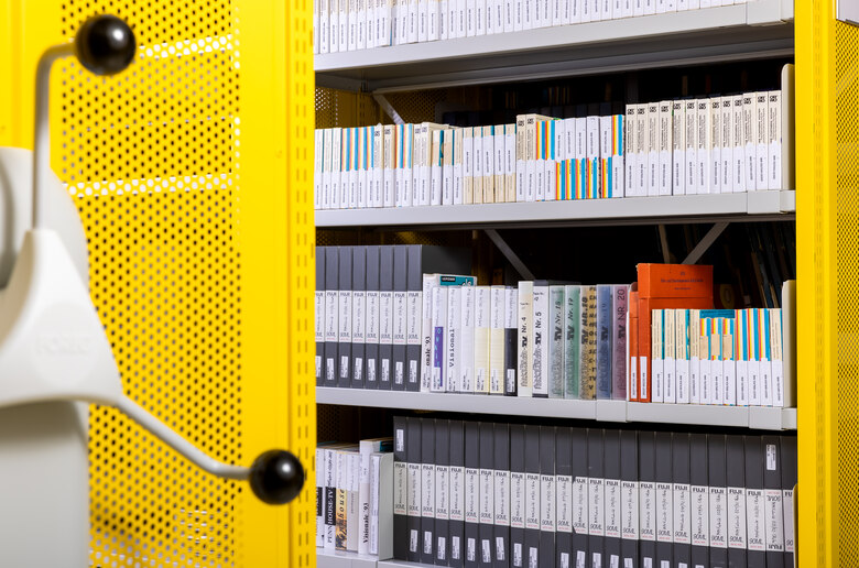 Das Foto zeigt links eine Rollregalkurbel und rechts ein Magazinregal voller verpackter Filmrollen.