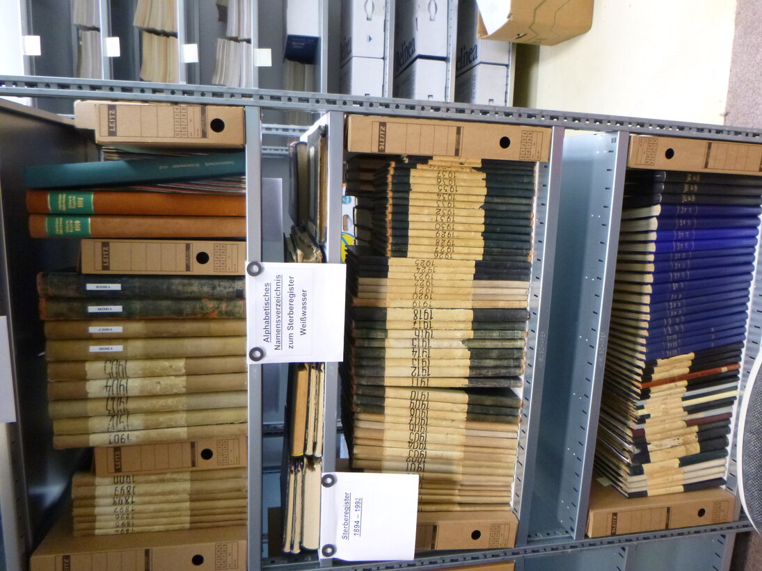 Regale mit darin liegenden Leitzordnern und gebundenen Akten.